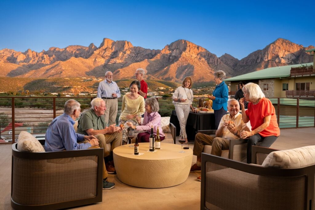 group of residents hang around the outdoor patio looking at the mountain