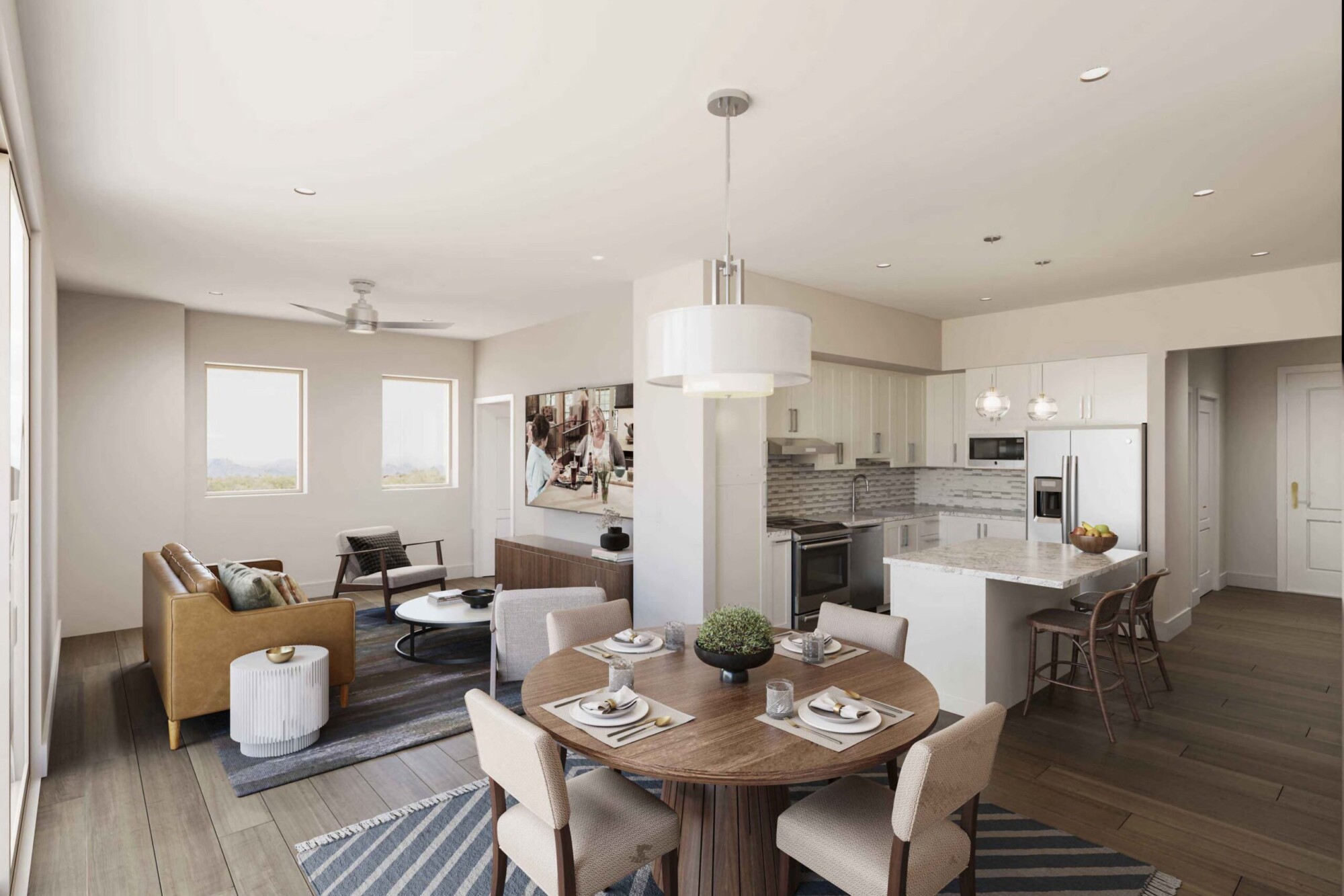 Purple Sage apartment interior showing an open-concept dining room, living area and white kitchen with stainless steel appliances and breakfast-bar seating. The dining area has a round table for four while the living room includes a leather sofa, accent chair, television and large windows.